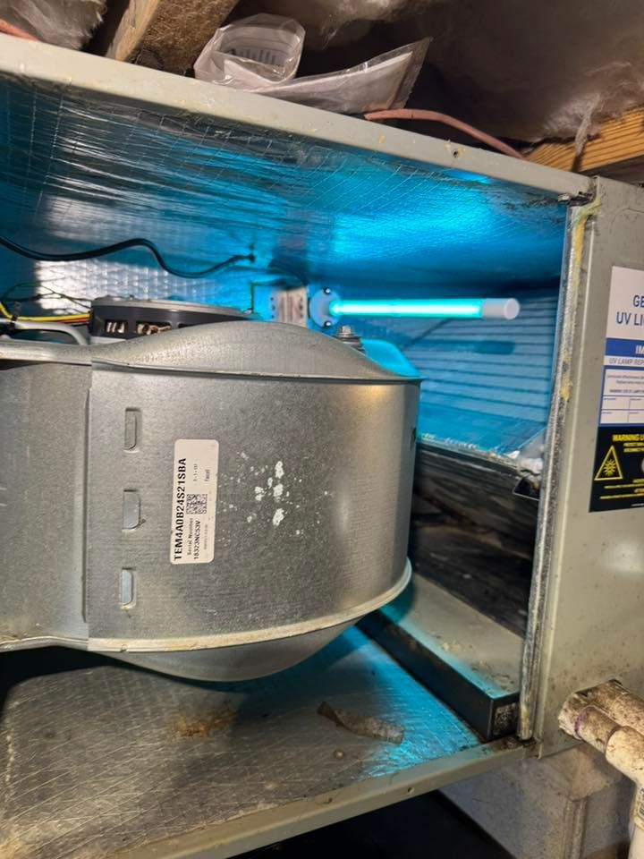 Skyline Comfort Services LLC - HVAC unit with blue UV light, metal ductwork, and a label.
