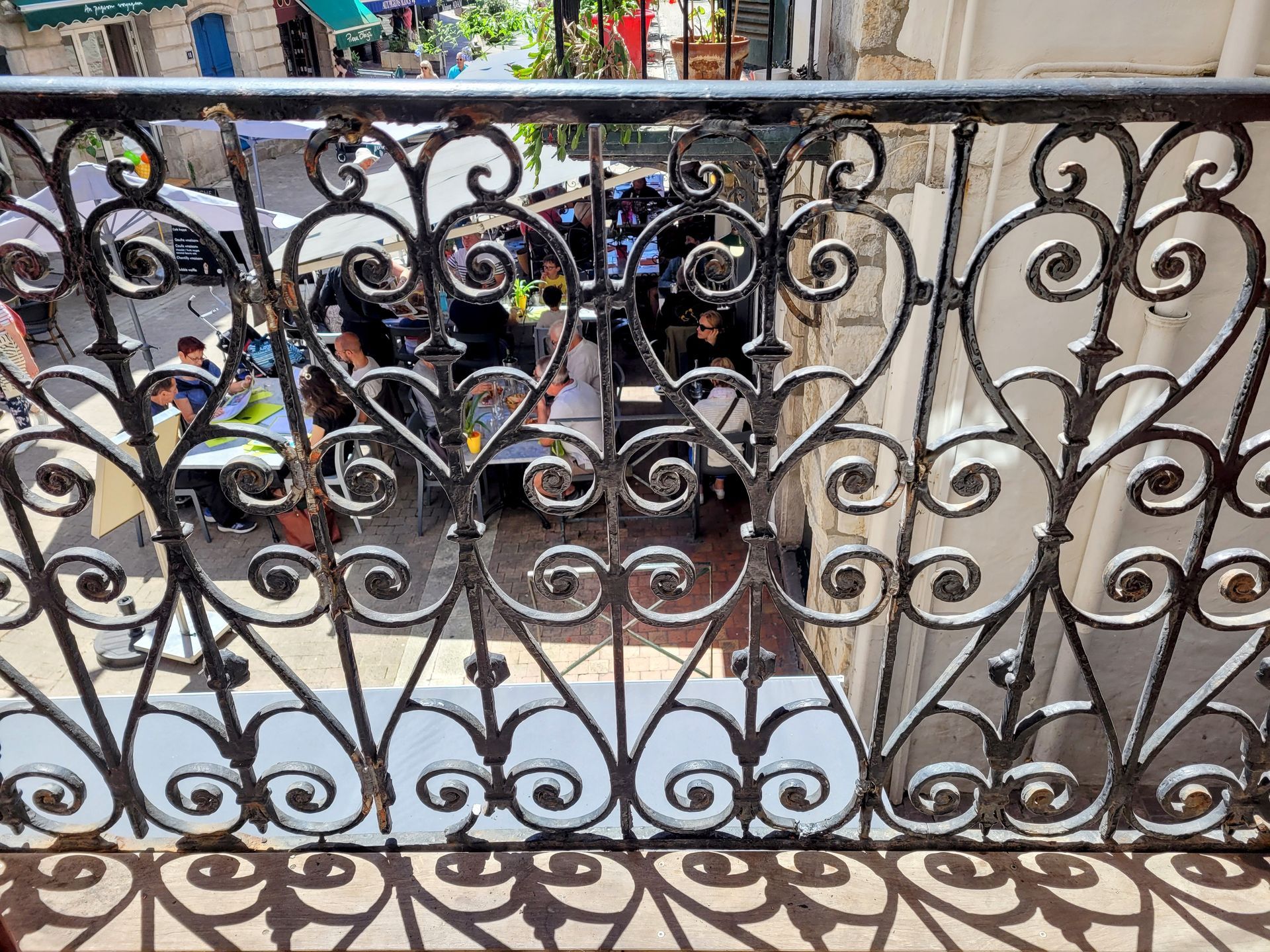un balcon avec une balustrade en fer forgé et une vue sur une rue de la ville.