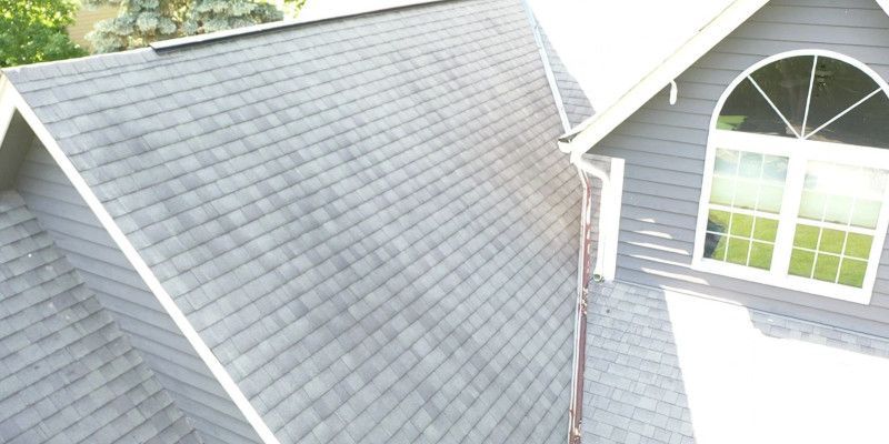An aerial view of a house with a gray roof and a window.