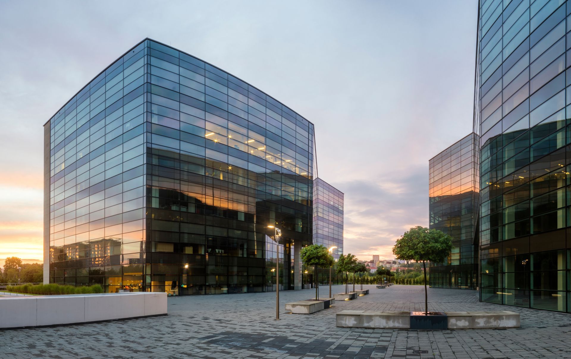 A large glass building with a lot of windows and trees in front of it.