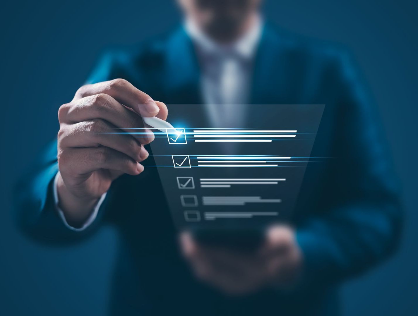 A man in a suit is holding a pen over a checklist on a screen.