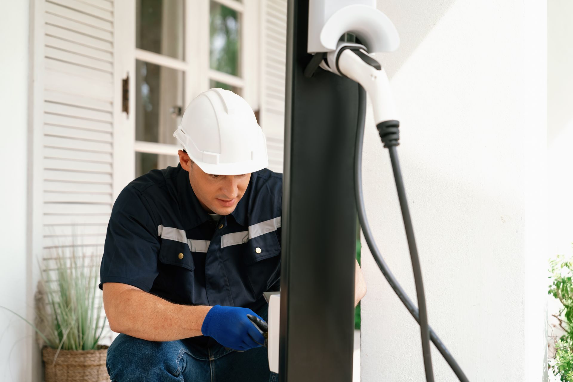 Two men are working on a electrical panel in a garage.