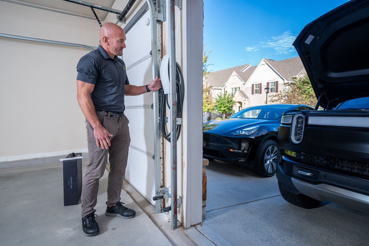 Professional installer setting up an electric vehicle (EV) charger in a residential garage, showcasi