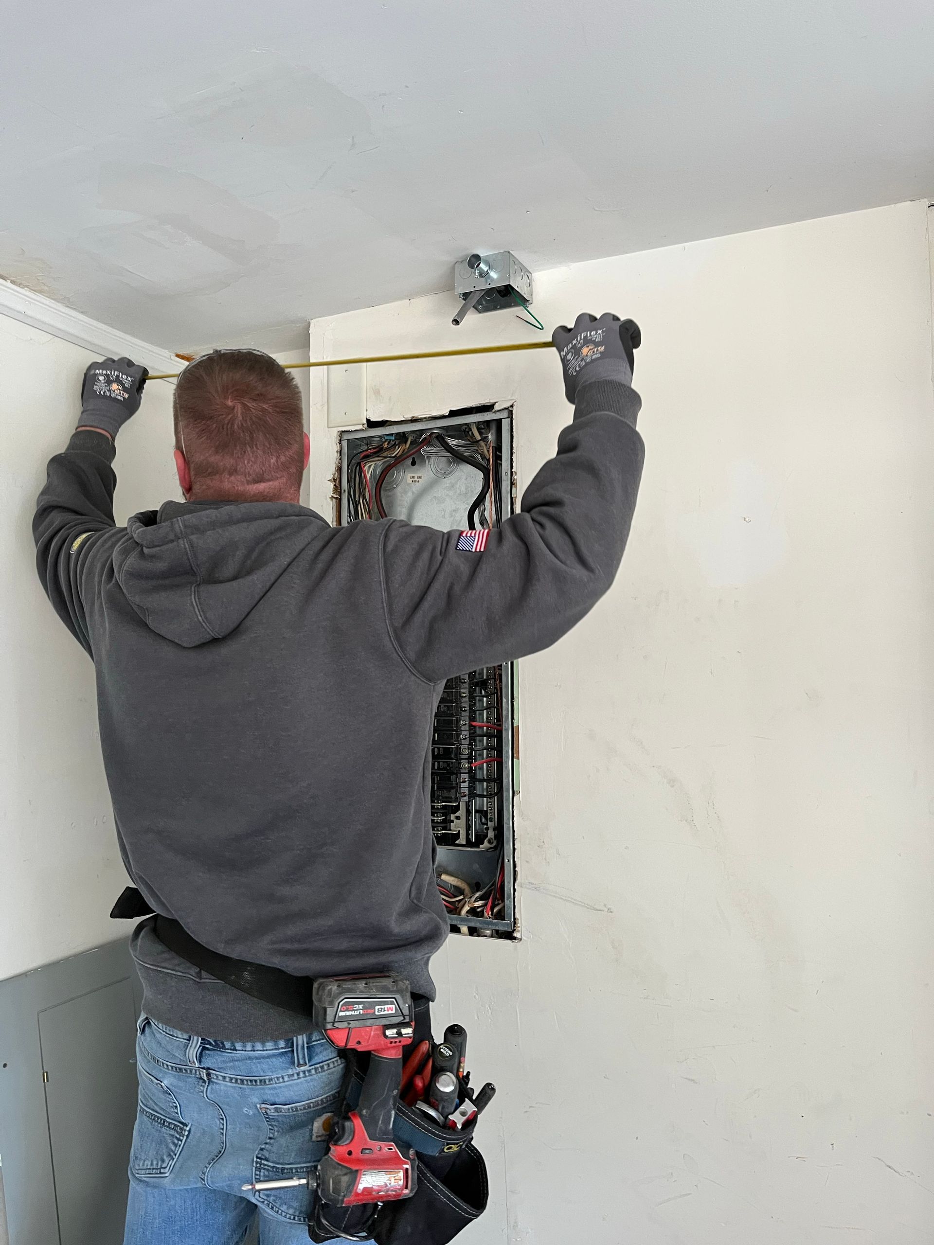 A man is measuring a wall with a tape measure.