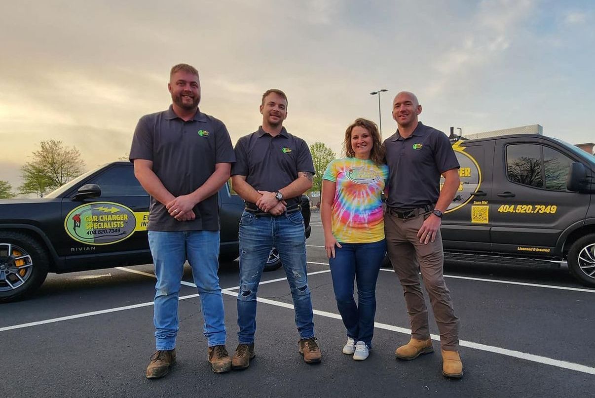 A group of people standing next to each other in a parking lot.