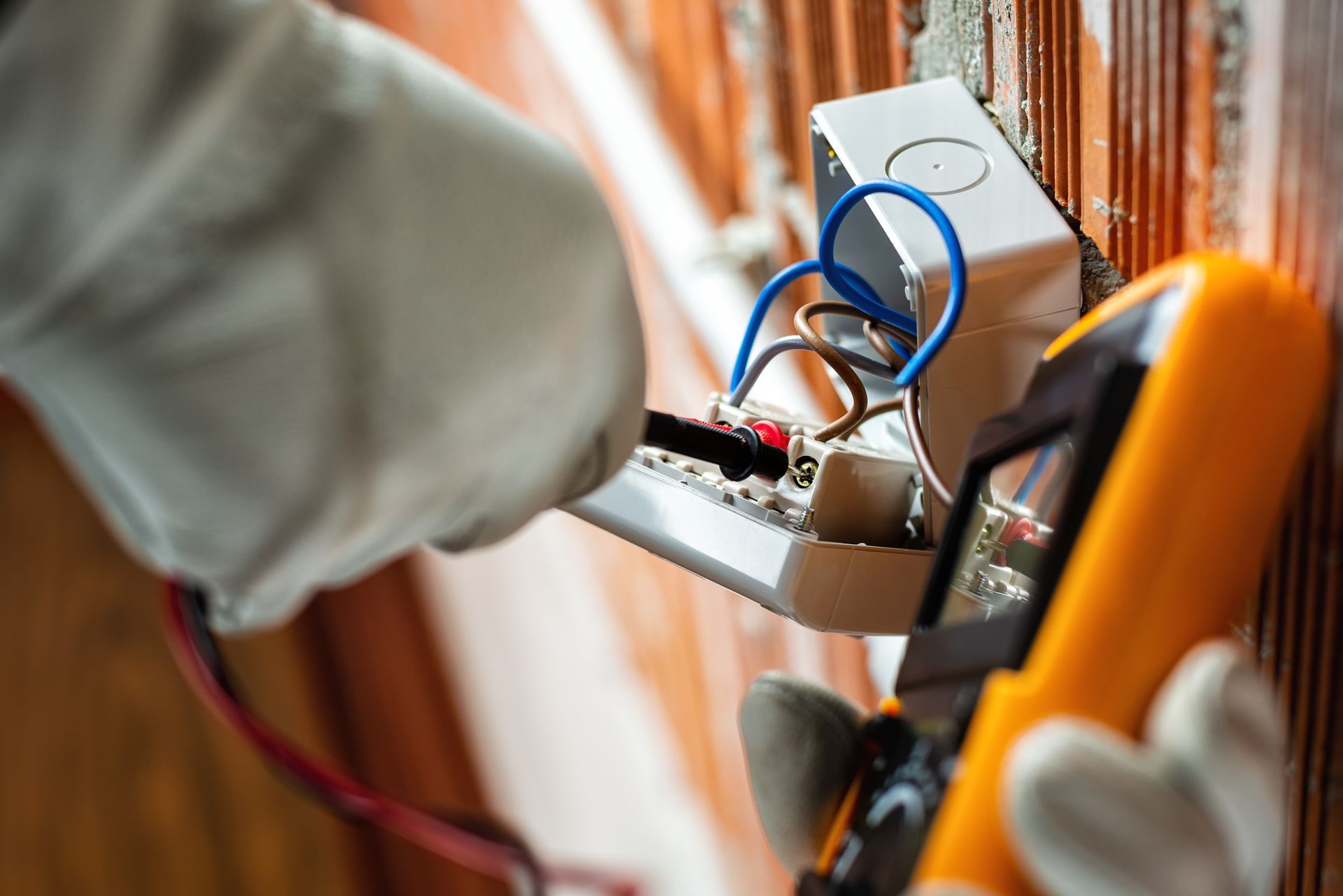 Electrician using a multimeter to test wires.