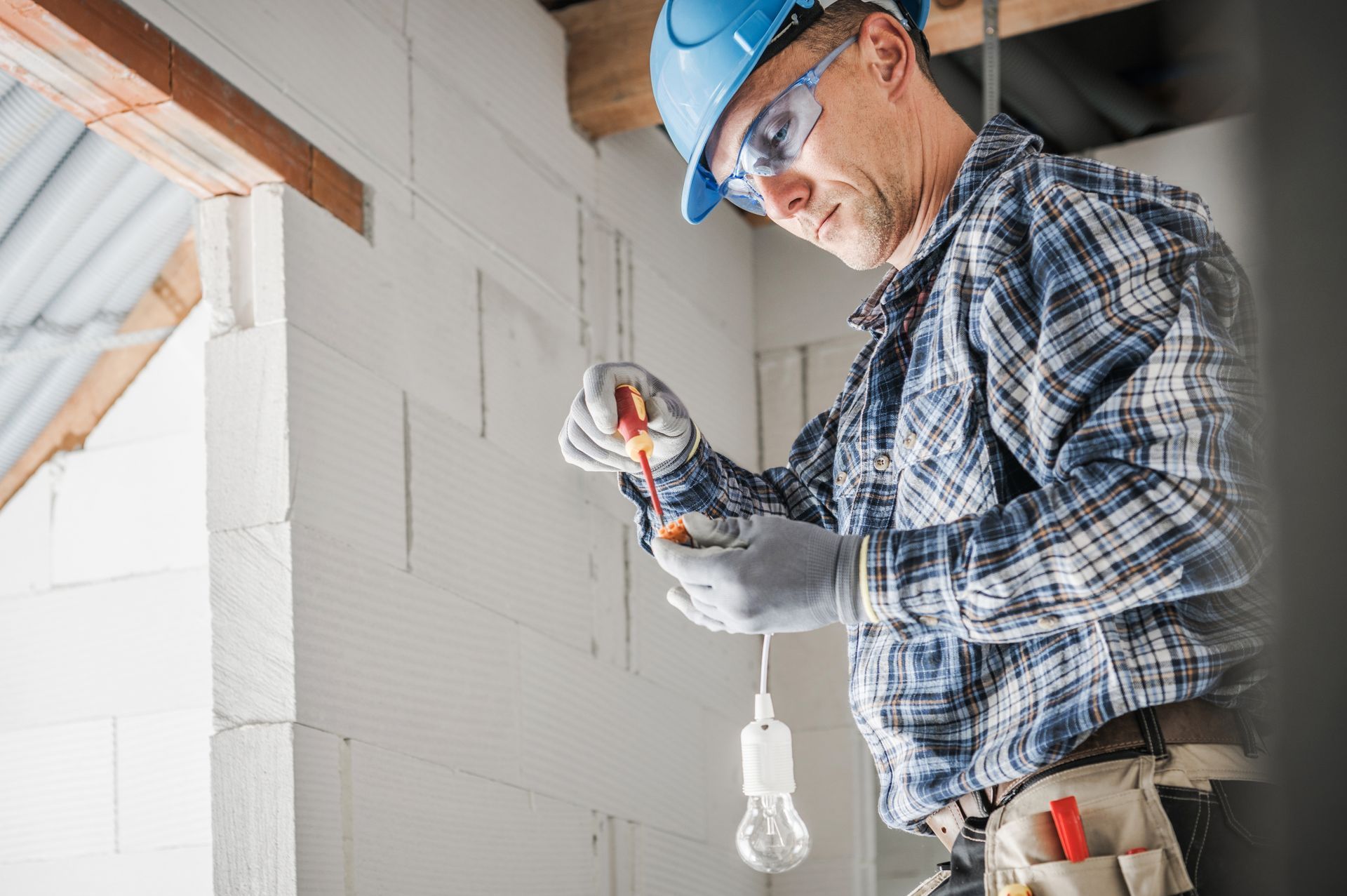 Electrician in blue hard hat working.