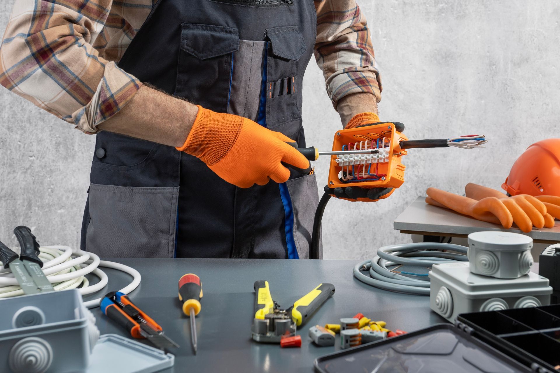 Electrician in orange gloves holding screwdriver set0