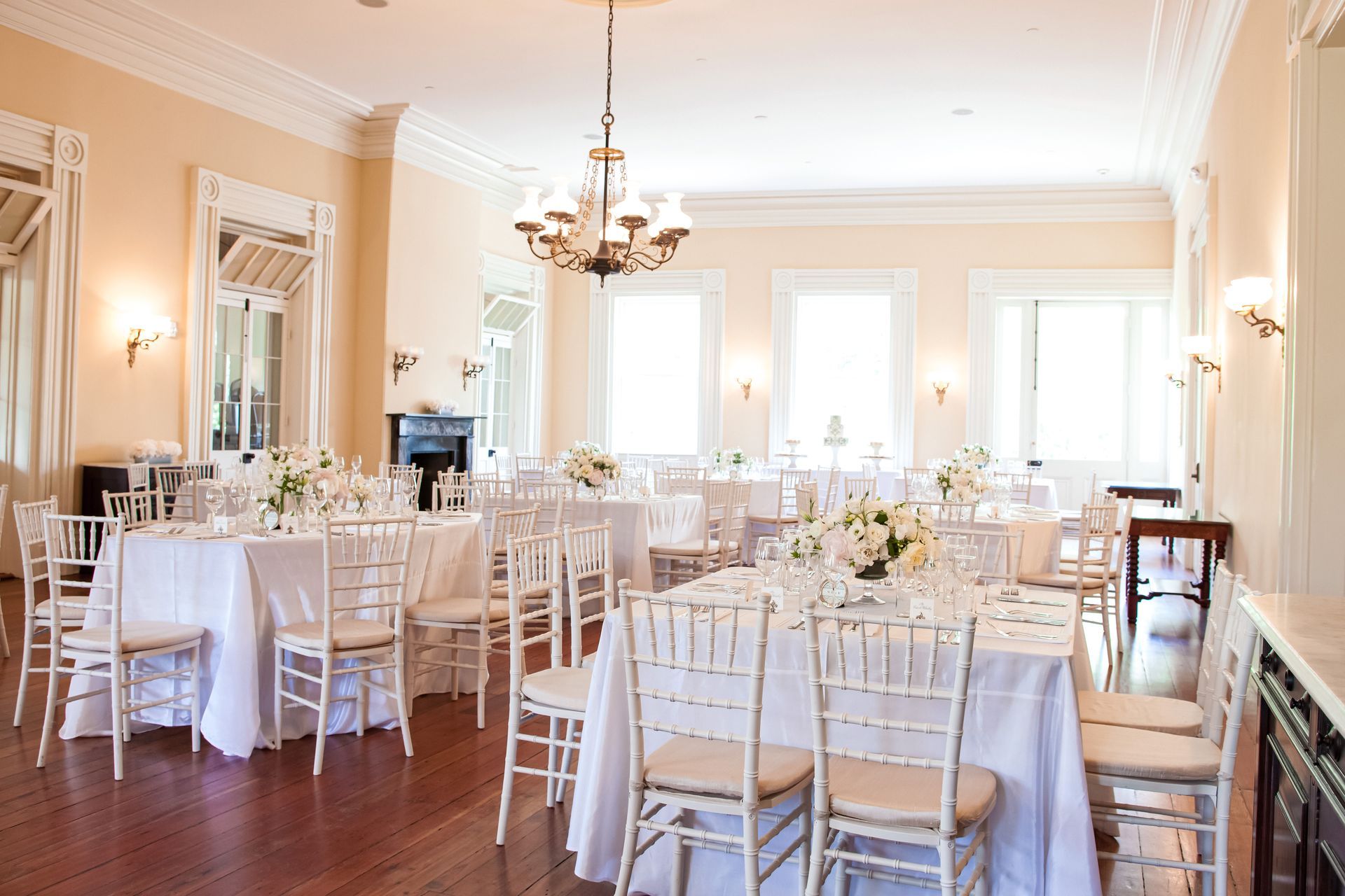 A large room with tables and chairs set up for a wedding reception.