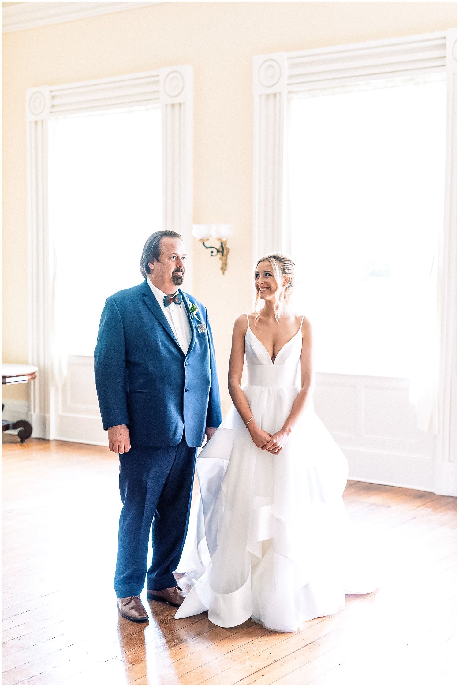 A bride and groom are standing next to each other in a room.