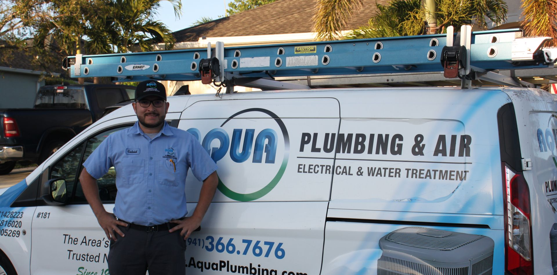 Man in blue uniform stands by a white van with 