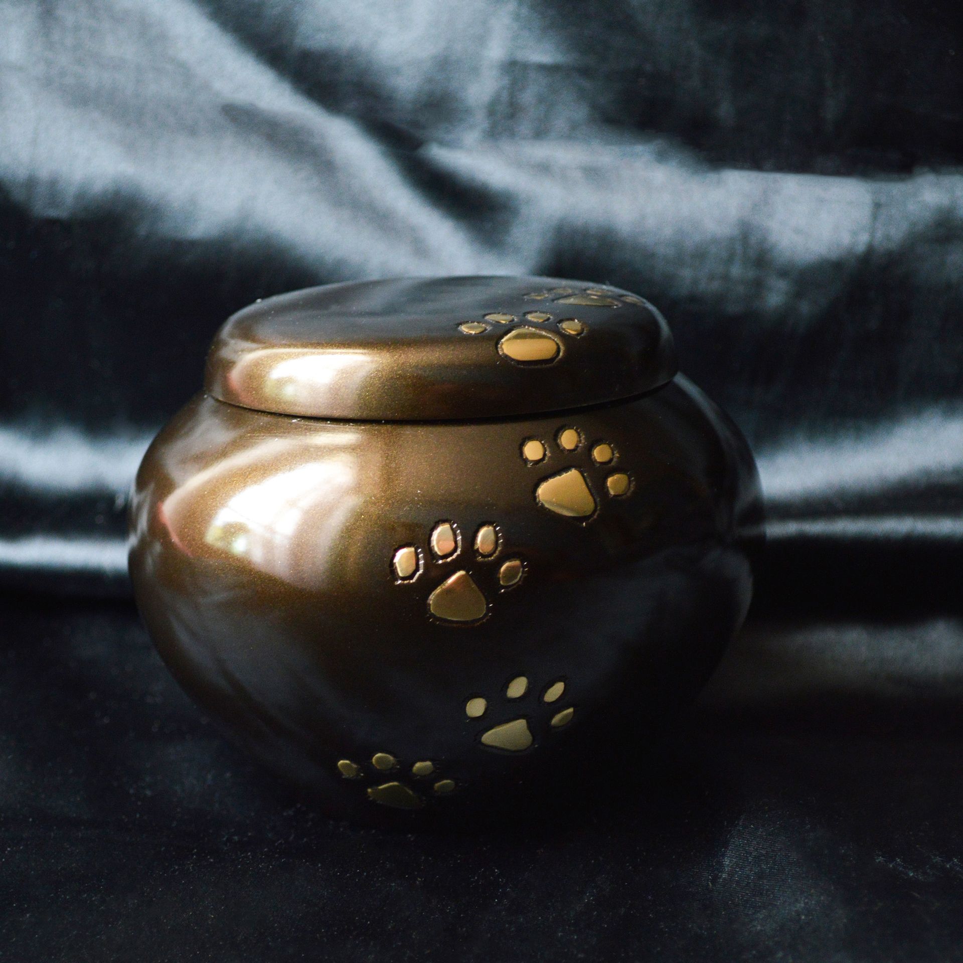 Bronze pet urn with gold paw prints.