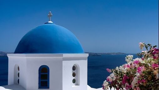 A white building with a blue dome on top of it.