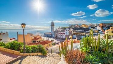 There is a staircase leading up to a city with a lighthouse in the background.