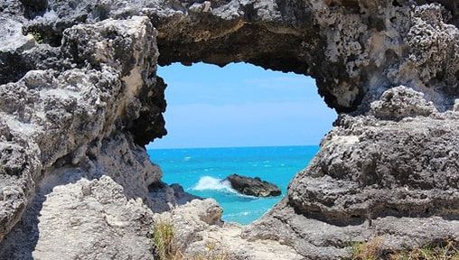 A view of the ocean through a rock archway.