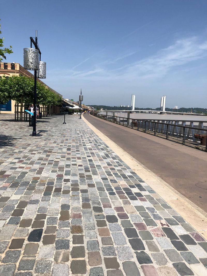 A cobblestone walkway leading to a body of water.