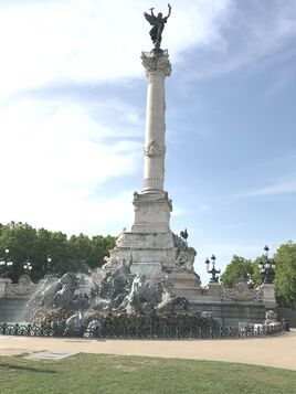 There is a large statue in the middle of a park.