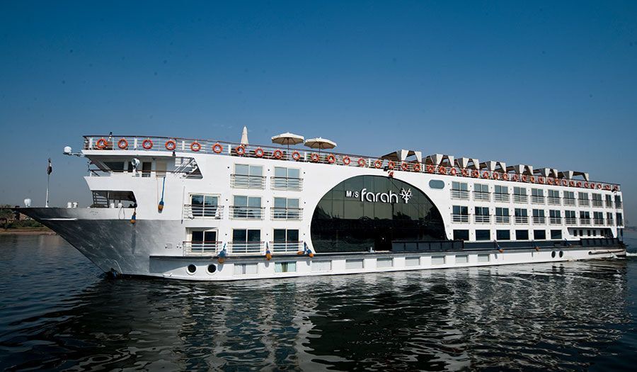 A large white cruise ship is floating on top of a body of water.