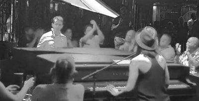 A woman is playing a piano in front of a crowd of people.