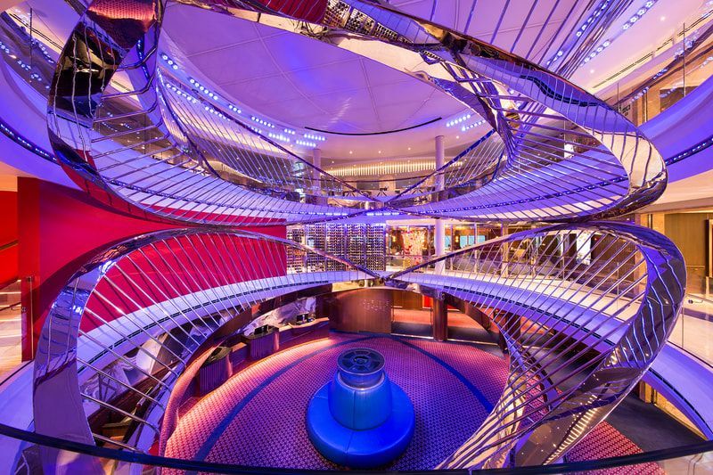 A spiral staircase in a building with purple lights.