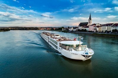 An aerial view of a cruise ship floating on top of a river.