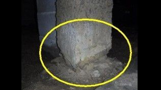 A close-up view shows a crumbling concrete pillar base in a dark, dirt-floored crawlspace, circled in yellow.