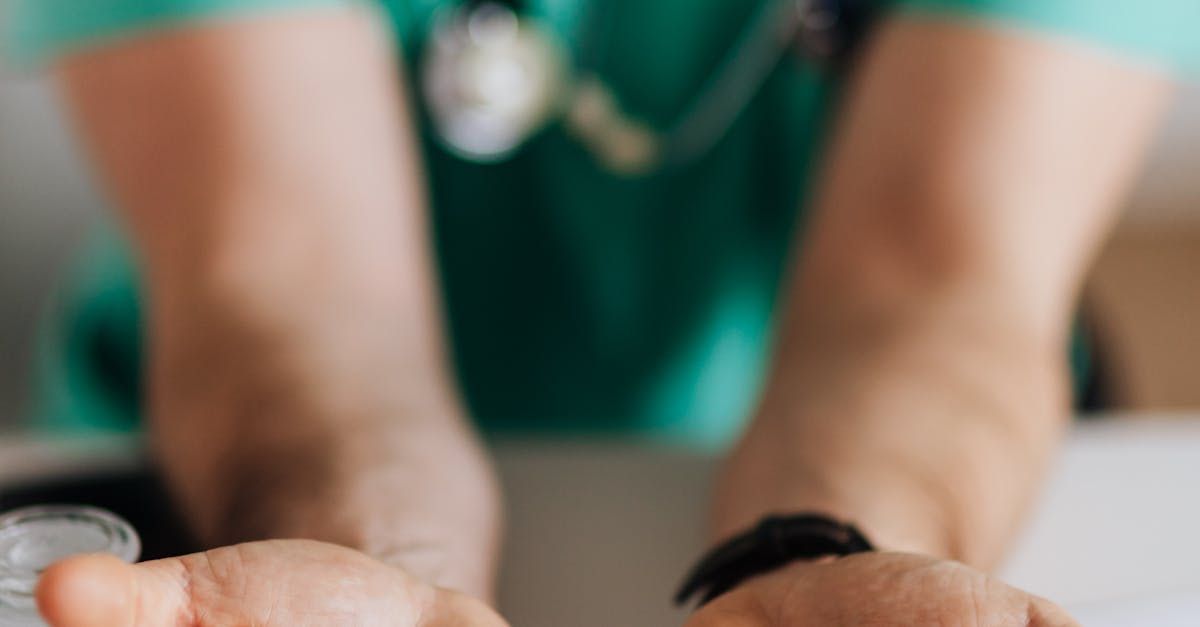 A nurse is holding a bottle of pills in her hand.