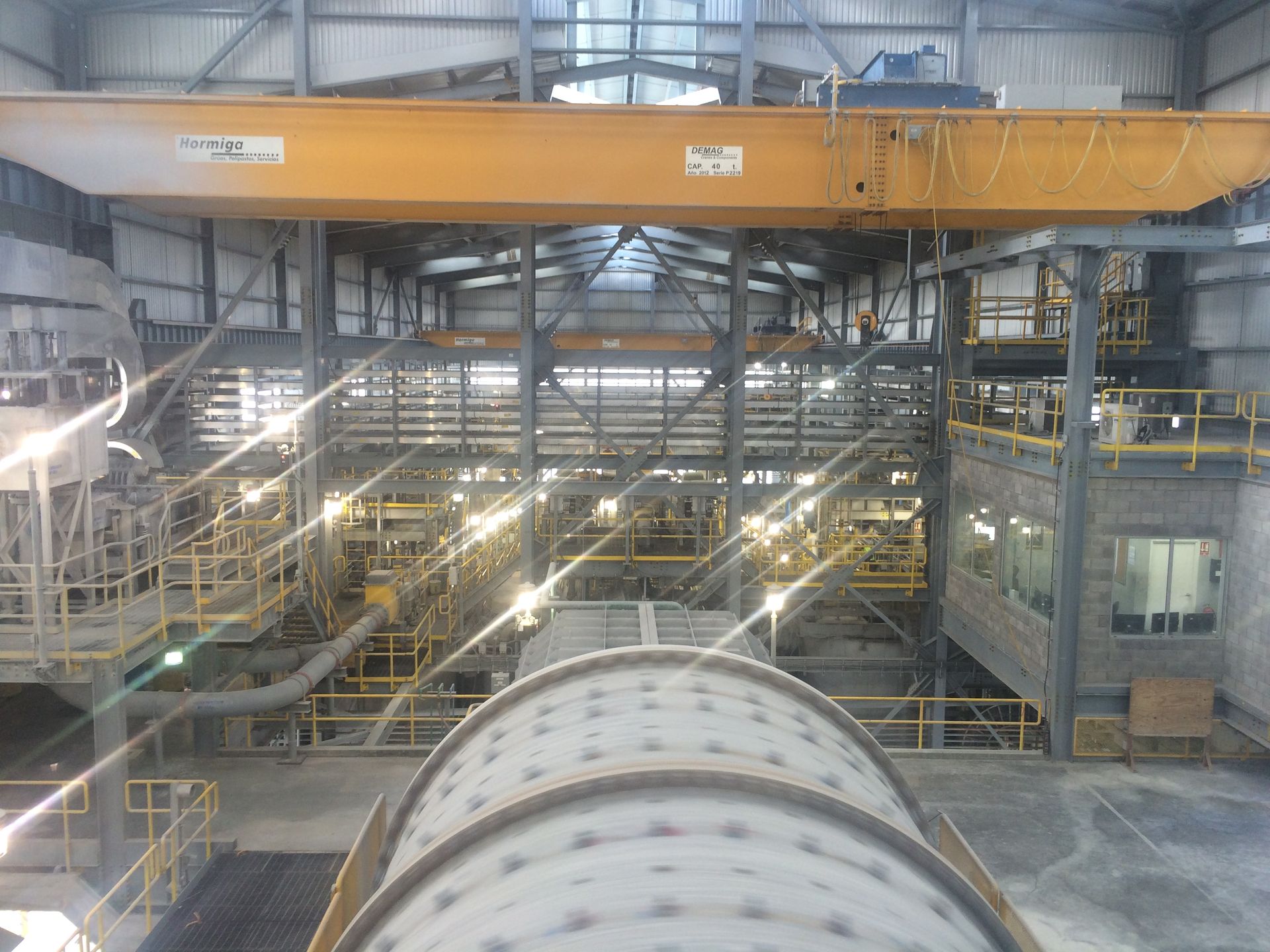 Man and woman reviewing papers together at a desk. Woman points, man wears glasses, smiles. Office setting.
