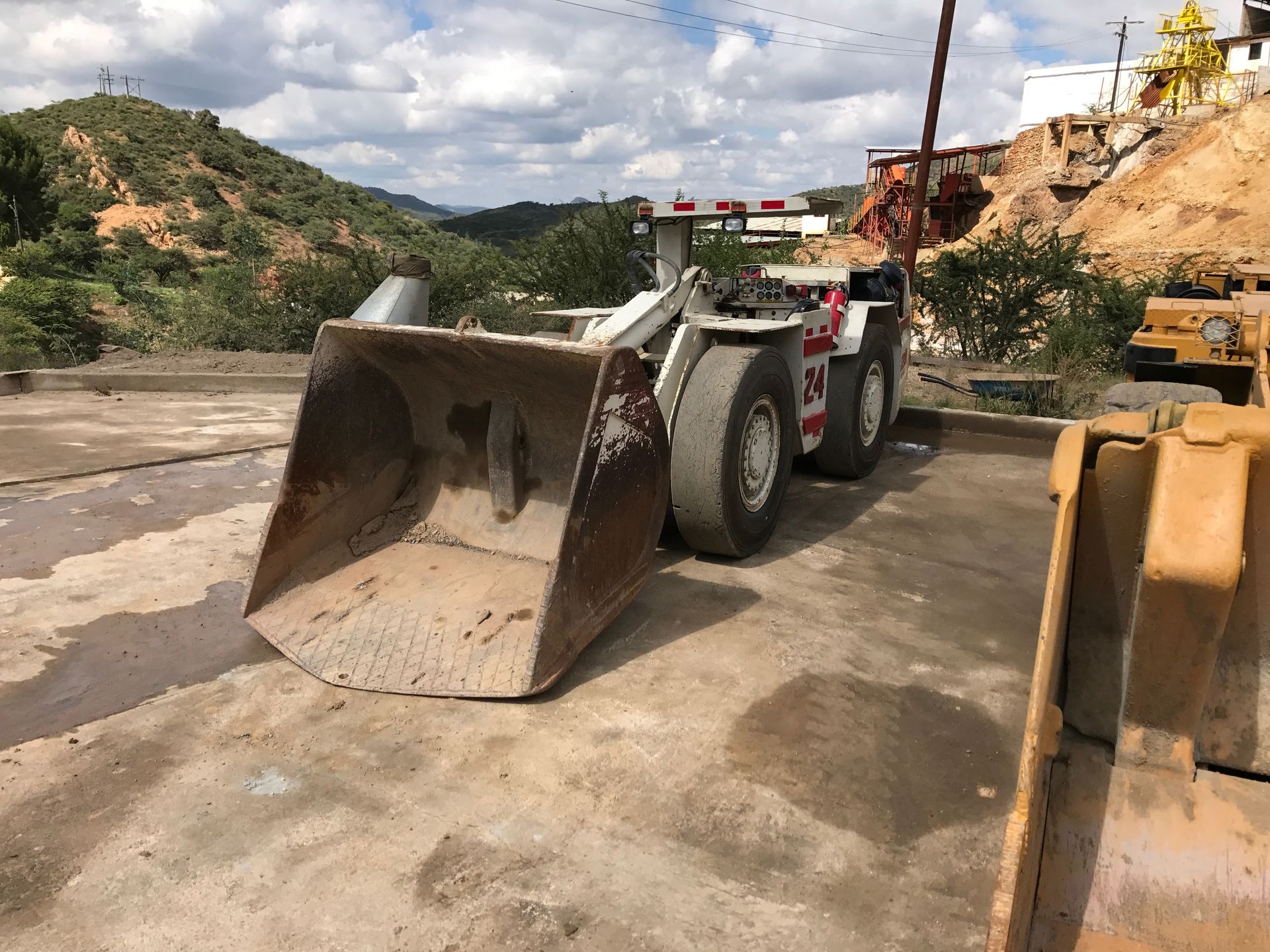 Person in suit pointing at tablet showing business graphs; two others in background.