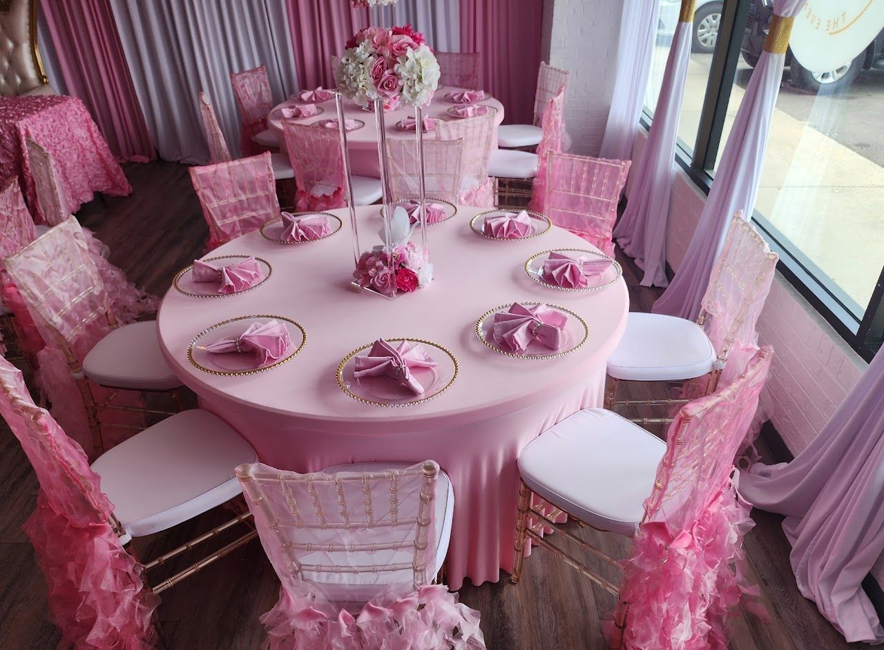 Pink-themed event with round table set for a party, including chairs and table cloths.
