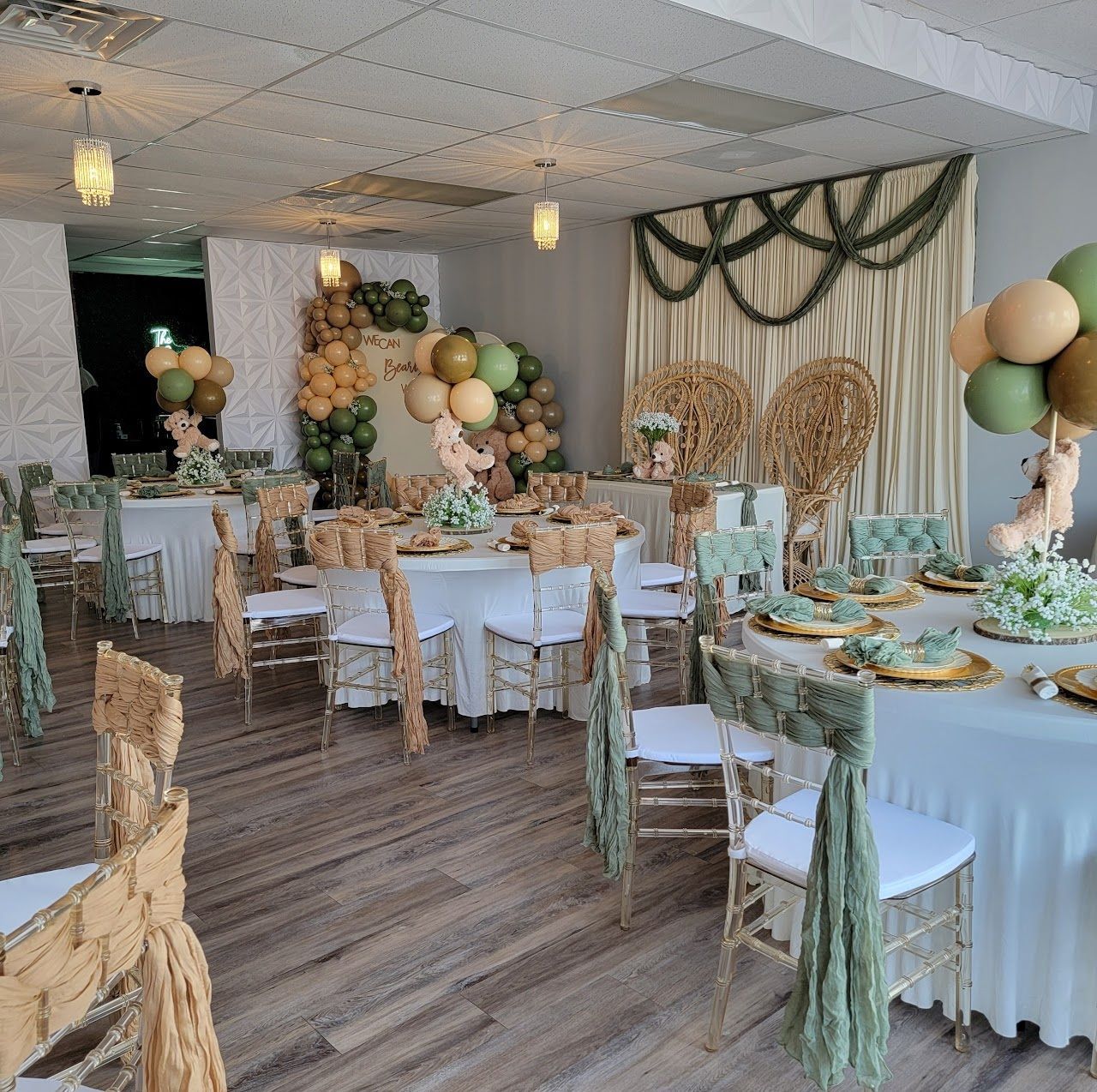 Interior of a banquet hall, tables set for a celebration with gold and green decorations.