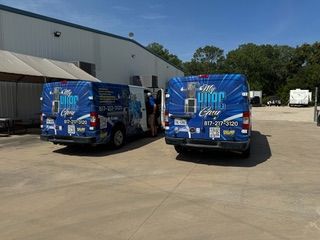 A man is working on an air conditioner on top of a building.