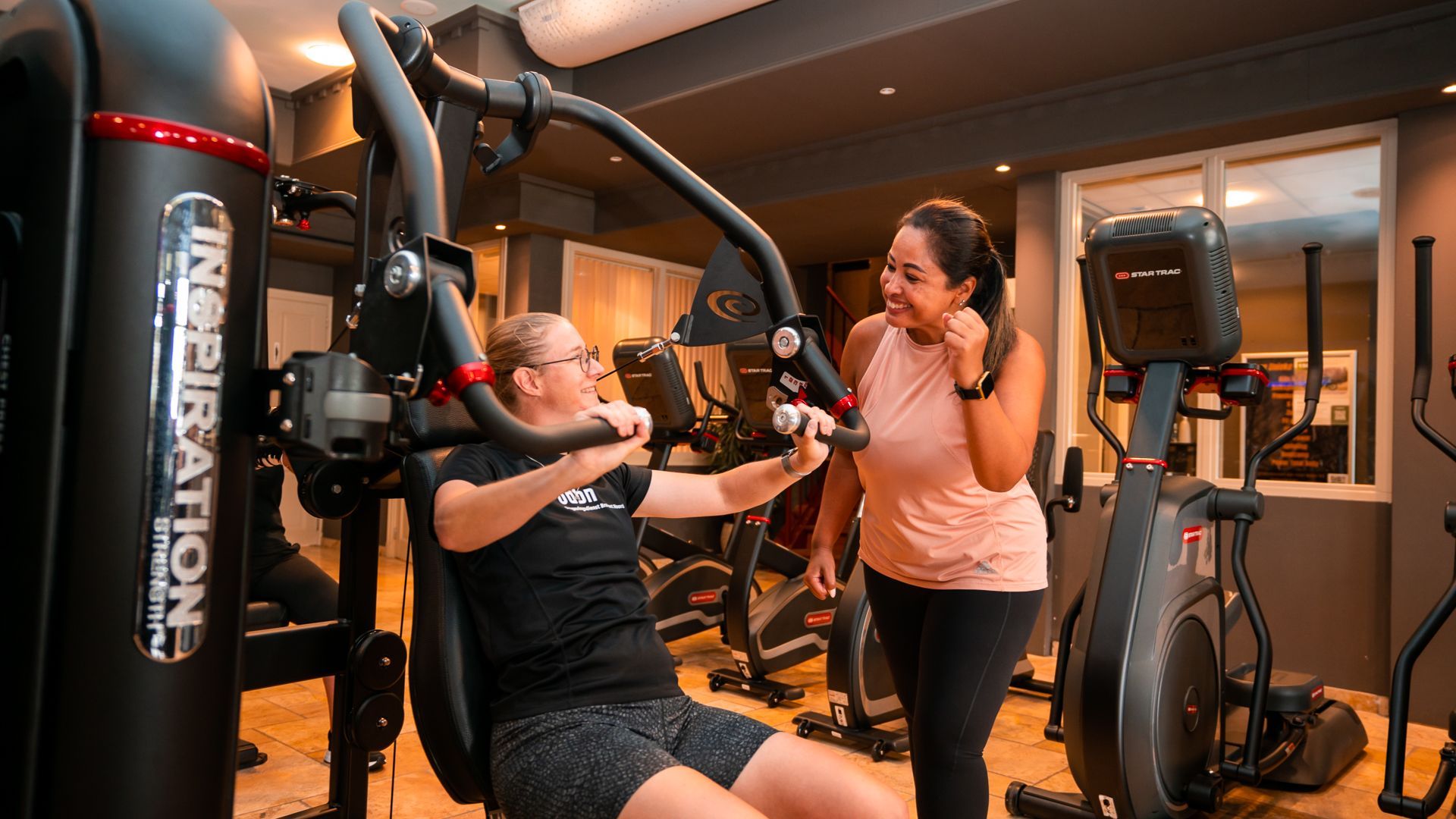 In een sportschool staat een rij hometrainers opgesteld.