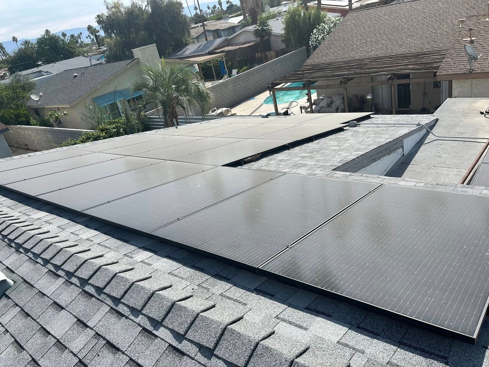 Solar panels installed on a sloped rooftop in a residential neighborhood