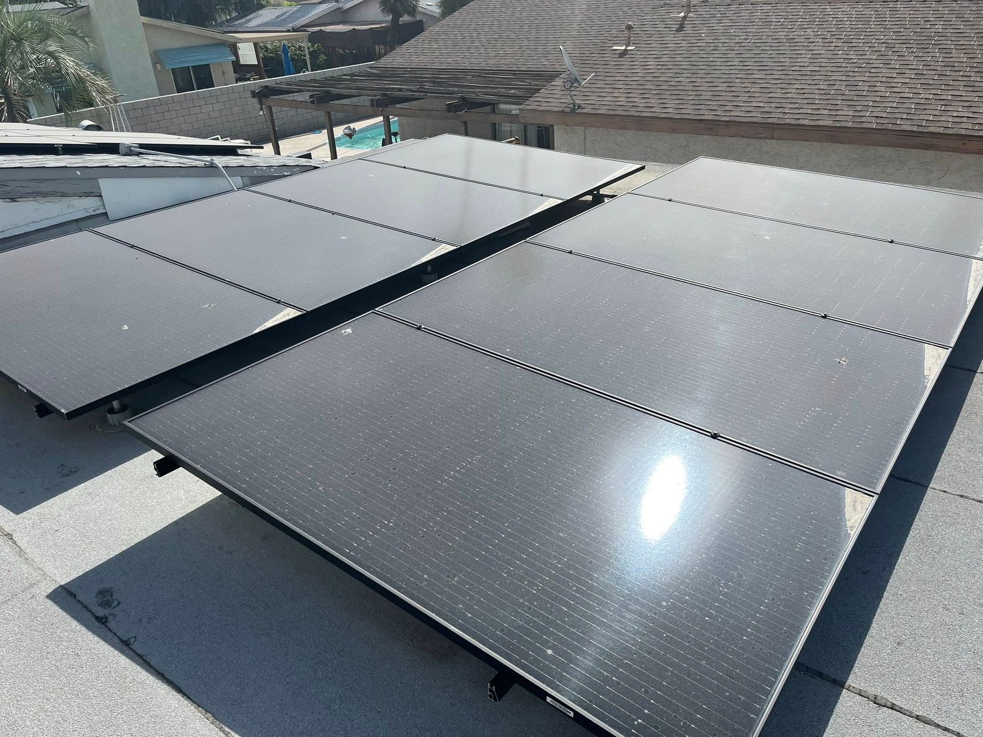 Solar panels installed on a rooftop under bright sunlight.