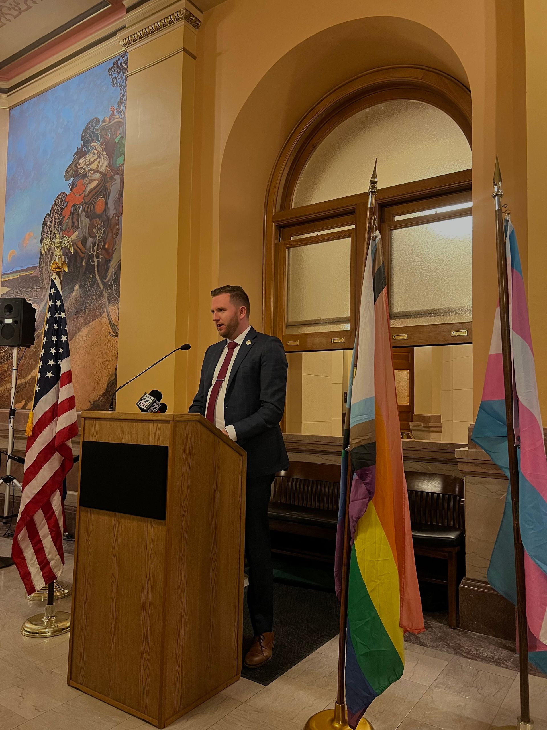 A man in a suit and tie is standing at a podium giving a speech.