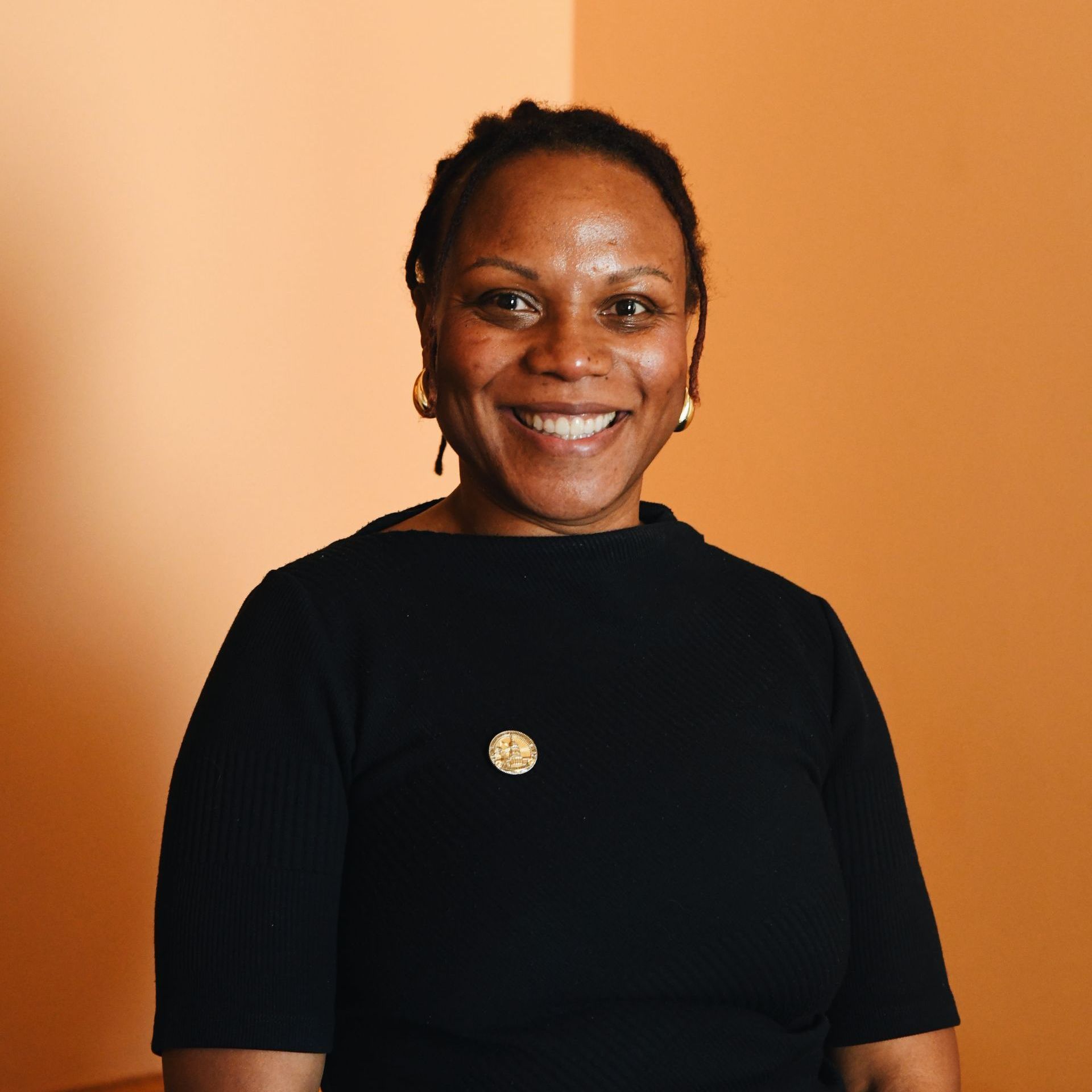 A woman in a black shirt is smiling for the camera