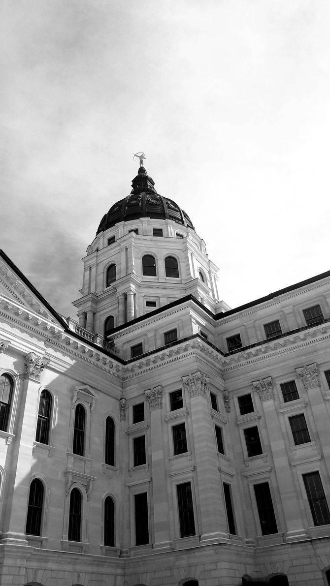 A black and white photo of a large building with a dome on top.