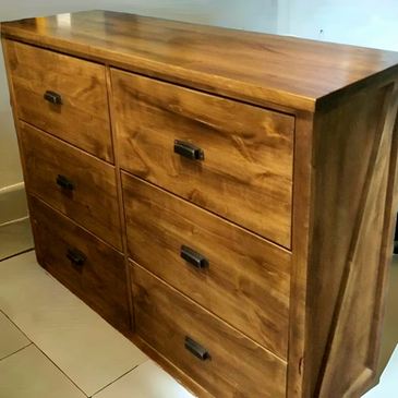 A wooden chest of drawers is sitting on a tiled floor