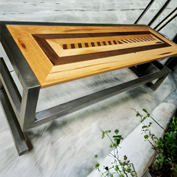 A wooden table with a metal frame sits on a concrete floor
