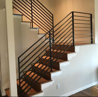 A staircase with a metal railing and wooden steps