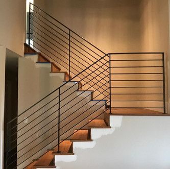A wooden staircase with a metal railing in a house.