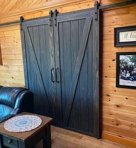 A living room with a couch , table , and sliding barn doors.