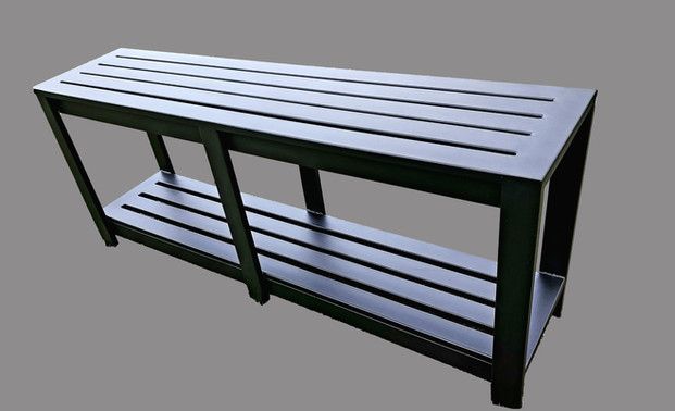 A black bench with a shelf underneath it