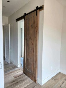 A sliding barn door in a hallway leading to a bathroom.