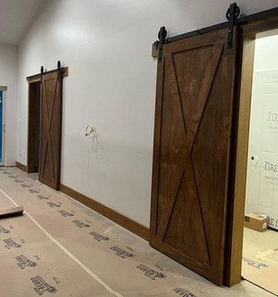A row of wooden sliding barn doors in a hallway.