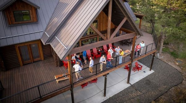 An aerial view of a group of people standing on a deck of a house.