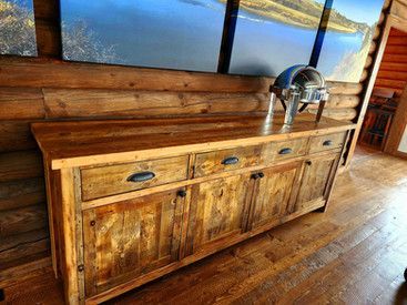 A wooden buffet table in a log cabin with a tray on top of it.