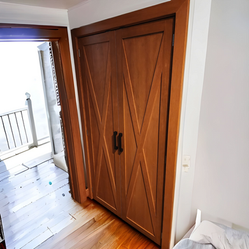 A bedroom with a wooden door and a bed