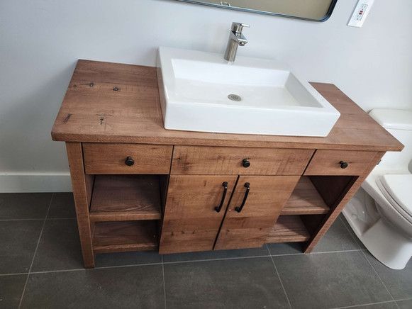 A bathroom vanity with a sink and a toilet